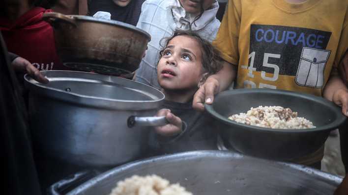 Kinder stehen in Schlange zur Essenausgabe einer NGO im Gaza-Streifen