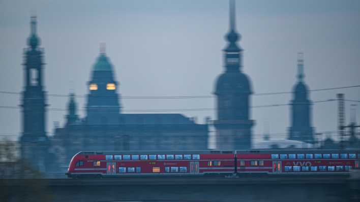 Eine S-Bahn fährt am Morgen vor der Altstadtkulisse Dresdens über die Marienbrücke.