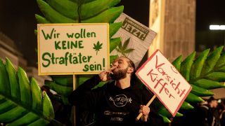 Ein Mann zieht bei einer Versammlung anlässlich der Legalisierung von Cannabis am Brandenburger Tor an einem Joint